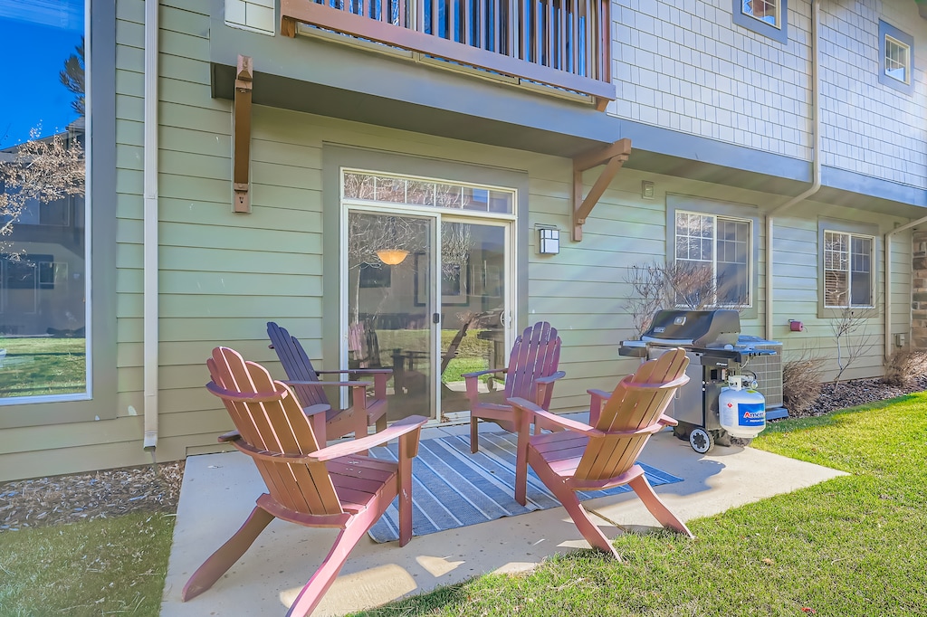 Your private patio awaits with Adirondack chairs, a grill, and a grassy backyard—perfect for morning coffee or evening barbecues under the open sky.