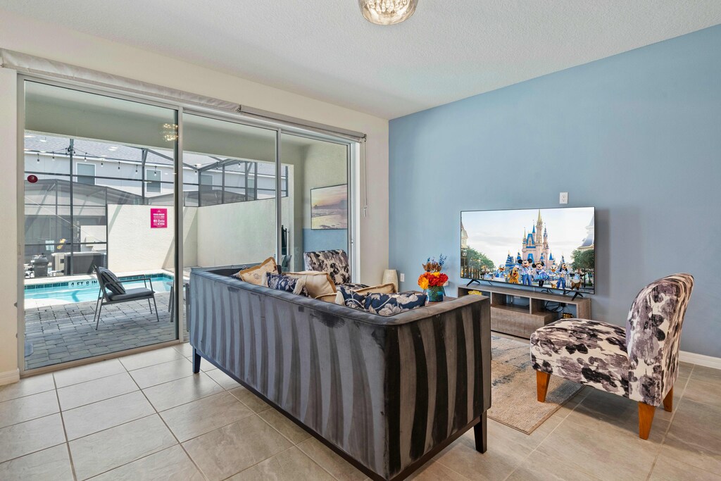 Spacious Living Area of the Townhouse in Kissimmee Florida - Smart TV and Netflix - Stylish furniture arrangement providing comfort and a cohesive look - Easy access to outdoor with seating and pool
