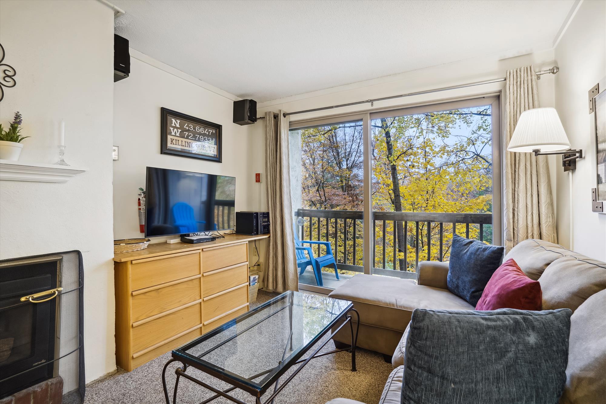 Living room with gas fireplace.  Lots of natural lighting with sliding glass doors, giving access to small decking.