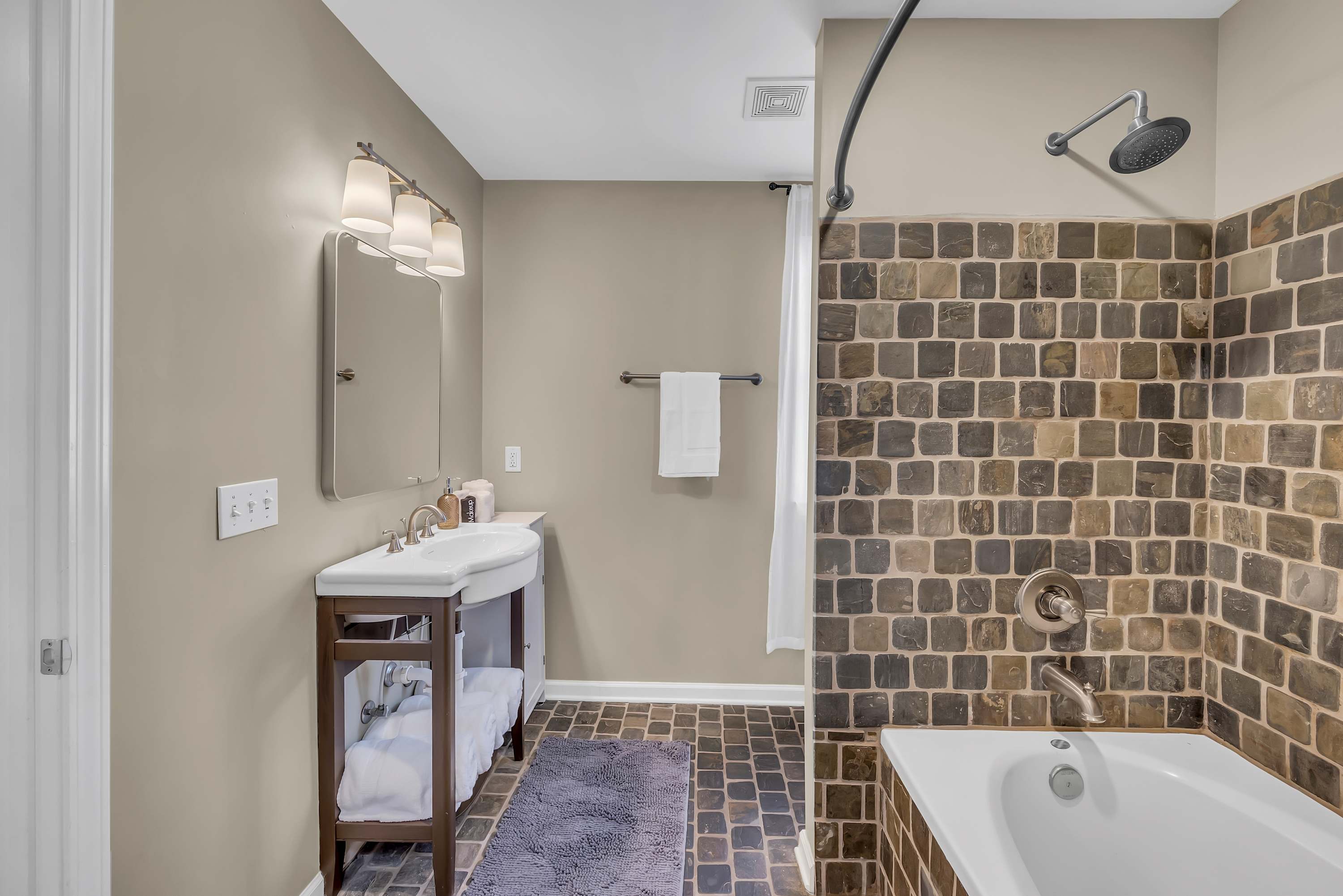  Refresh and unwind in our serene ensuite bathroom adorned with natural stone.