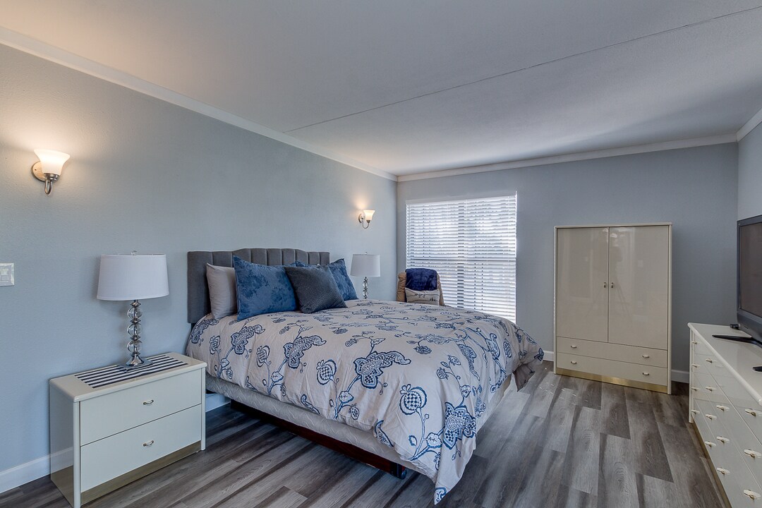Master bedroom has a plush queen bed and large TV;