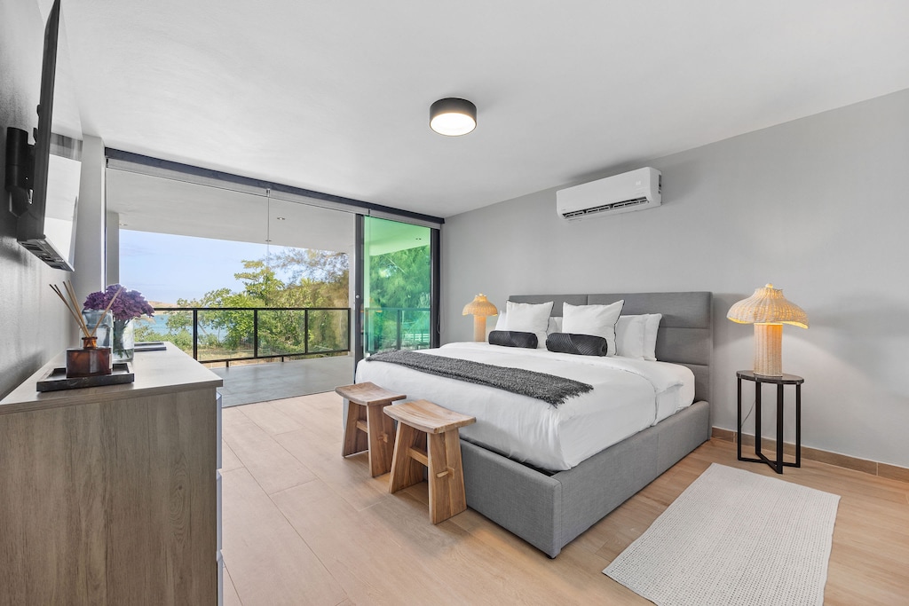 The master bedroom has a king bed, balcony with pluunge pool, TV, and ensuite bathroom.