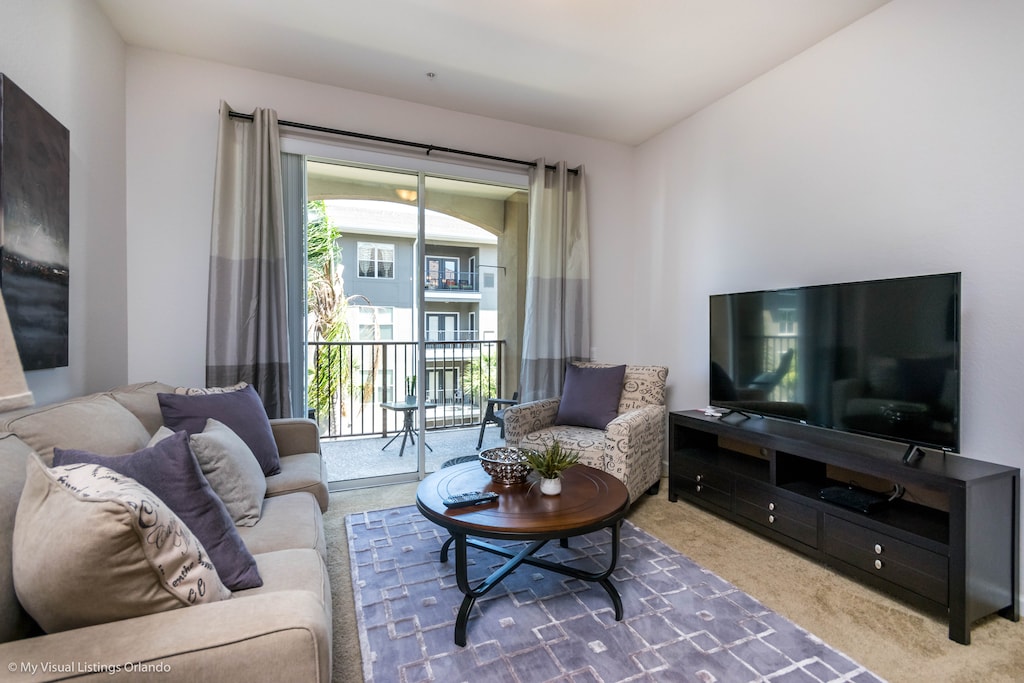 Serene living area of the condo in Orlando Florida - Natural light floods the room, enhancing its warmth and inviting atmosphere - Smart TV for entertainment - Thoughtful mix of textures, from plush rugs to tasteful throw pillows - Cozy Sofas