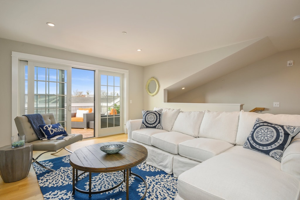 Second floor bonus room with large sectional, leather chair and entrance to roof top terrace.