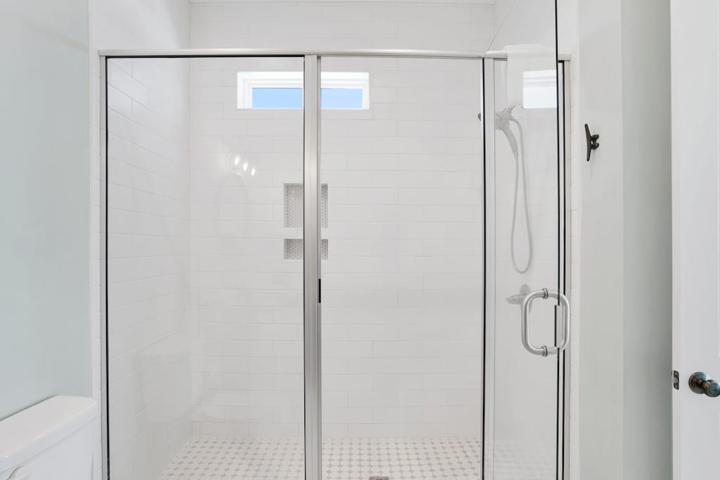 The guest bathroom features a walk-in, tile shower