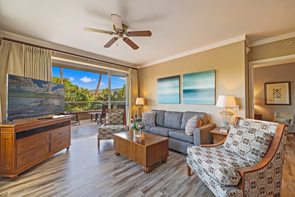The living room at Honua Kai Konea 232 features a sleeper sofa and large windows with ocean glimpses.