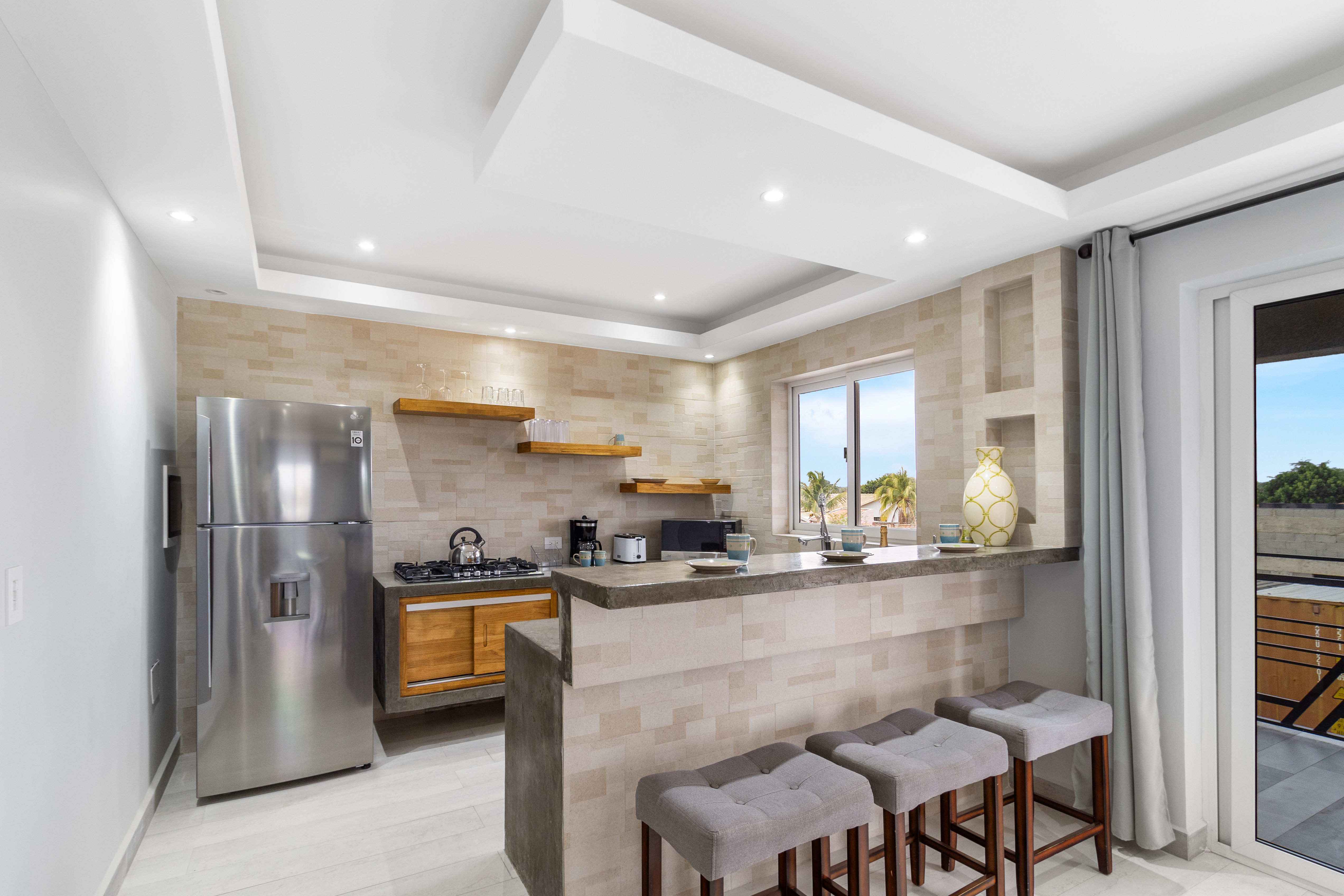 Beautiful kitchen of the apartment in Oranjestad Aruba - Modern kitchen with stainless steel appliances - Breakfast bar and high chairs - Thoughtful placement of kitchen essentials for easy access
