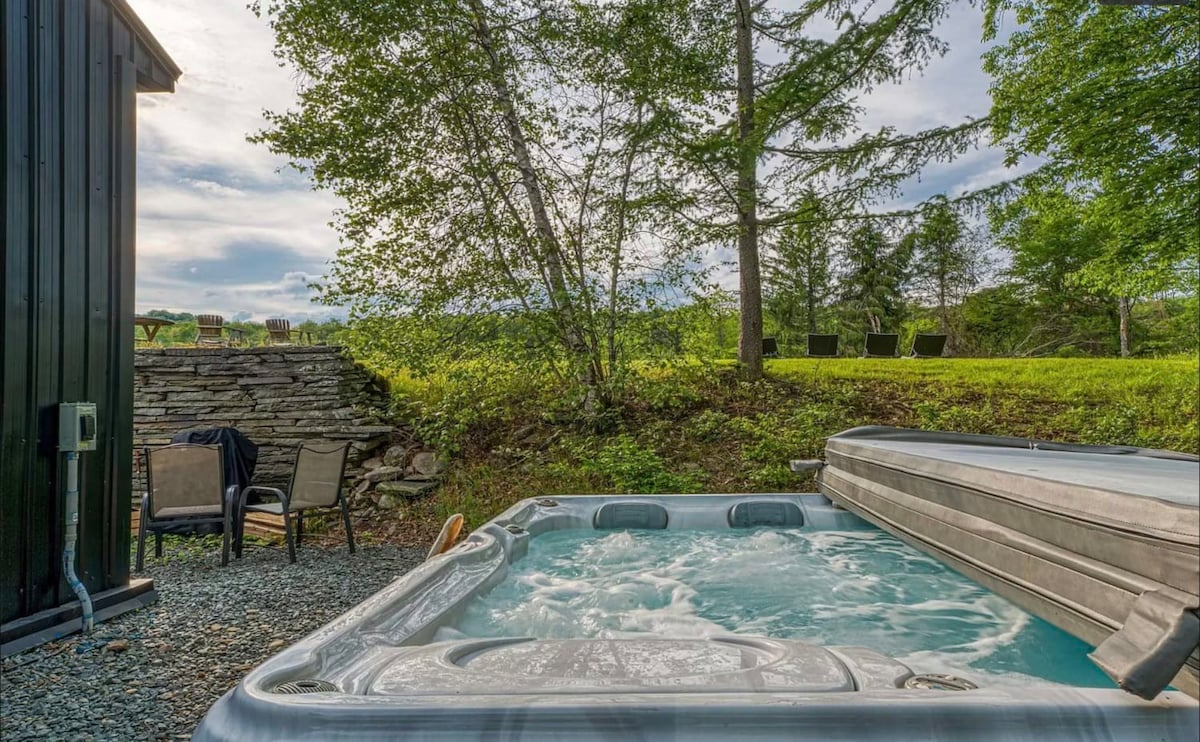 Enjoy relaxing in the hot tub surrounded by view of the beautiful property and forest.