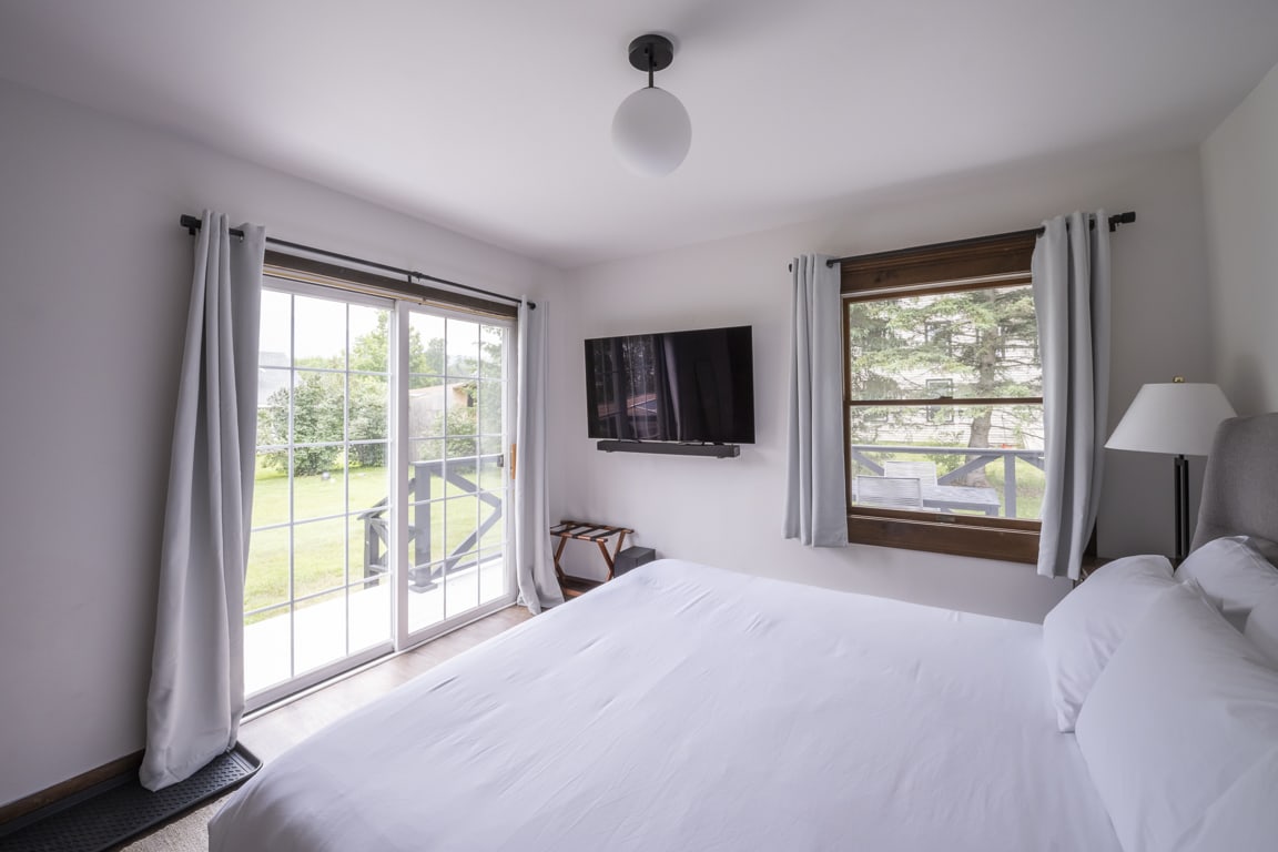 Bedroom 2 features a comfortable and spacious king bed and a sliding glass door for easy access to the outdoor deck.