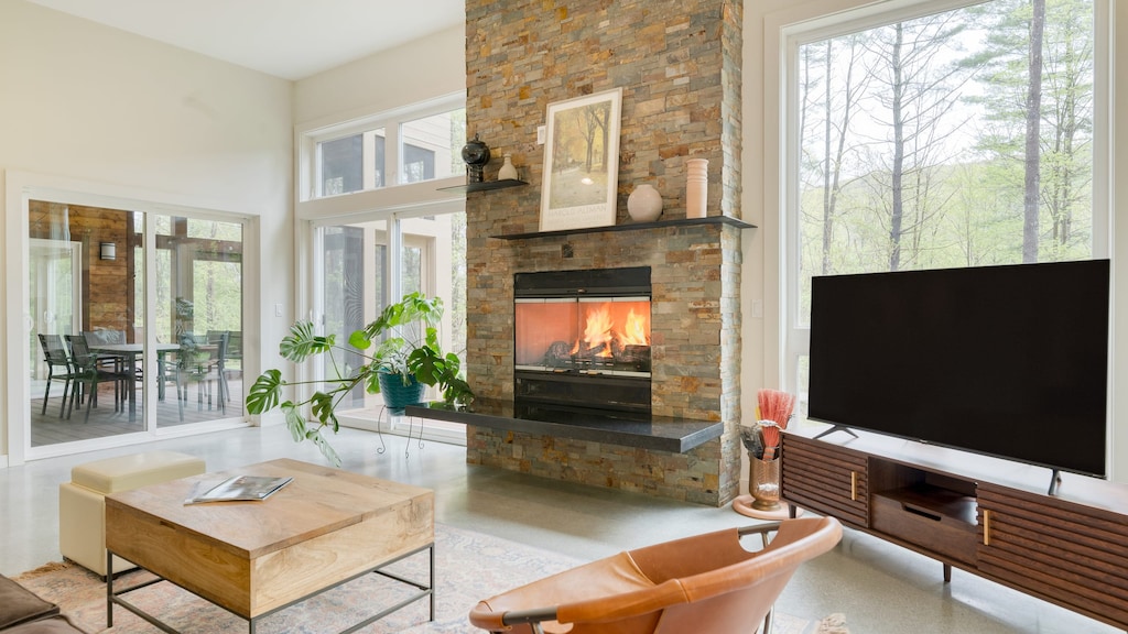 Bright, open living room with a large fireplace, plush seating, and TV.