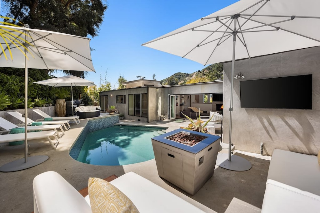 Discover the allure of the poolside fire pit, surrounded by plush seating.