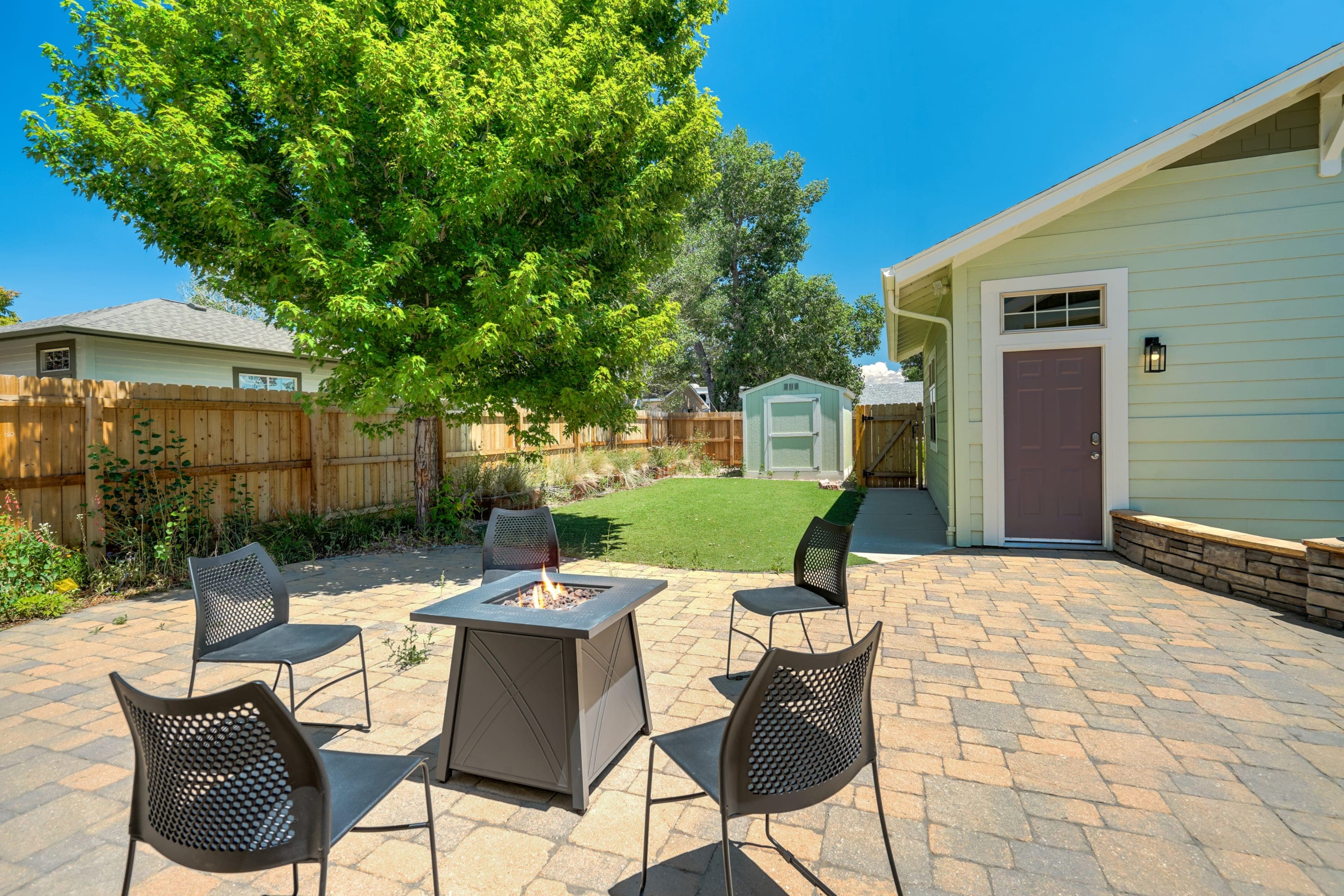 Unwind in our private backyard featuring a fire pit, comfortable seating, and a beautifully landscaped patio area.