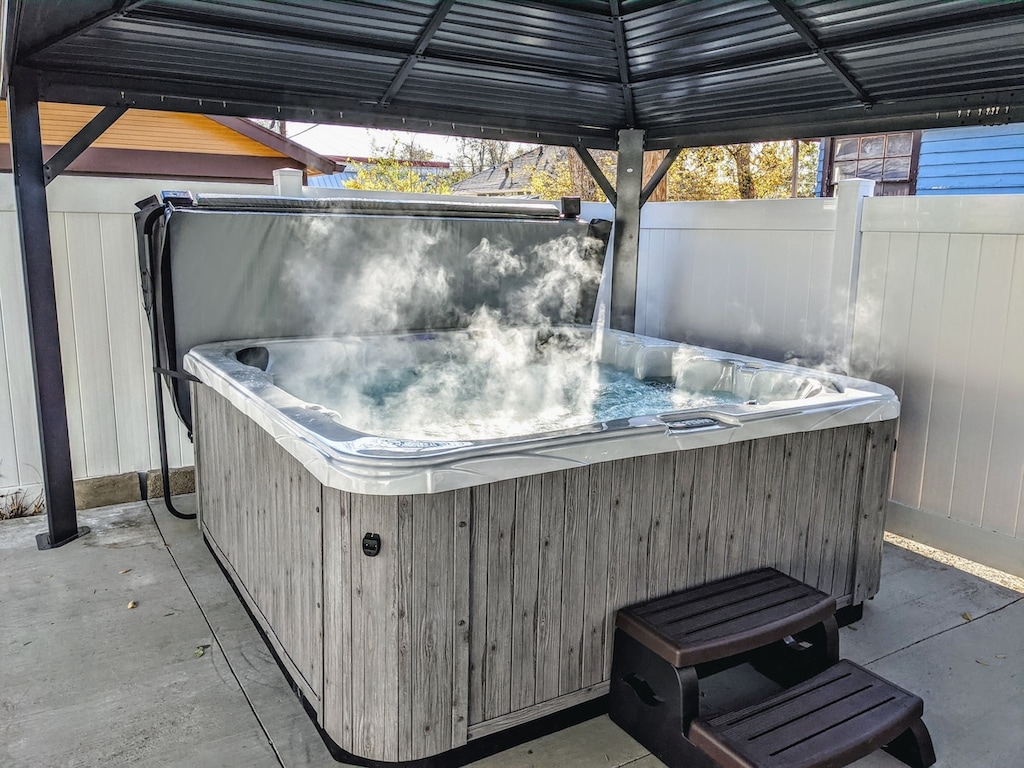 Enjoy a soothing soak in the hot tub, sheltered under a gazebo with ambient lighting—your perfect spot to relax and recharge..