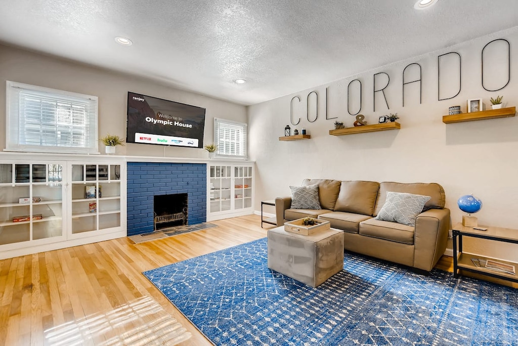 Welcome to Olympic House! Relax and hangout in the spacious living room that features 2 queen-sized pull-out sofas and a 65 inch 4k Roku Smart TV over a beautiful, decorative brick fireplace.