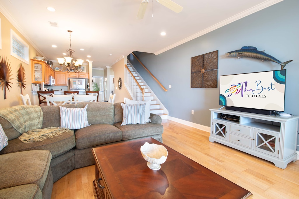 Settle into your cozy living space with plush sectional seating, where nautical decor and warm wood floors create the perfect coastal retreat atmosphere.