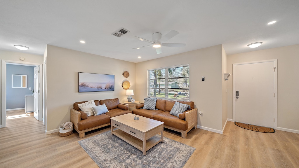 Unwind in the bright, open-concept living area featuring comfortable leather seating, chic coastal decor, and a Smart TV perfect for streaming your favorite shows after exploring Sarasota.