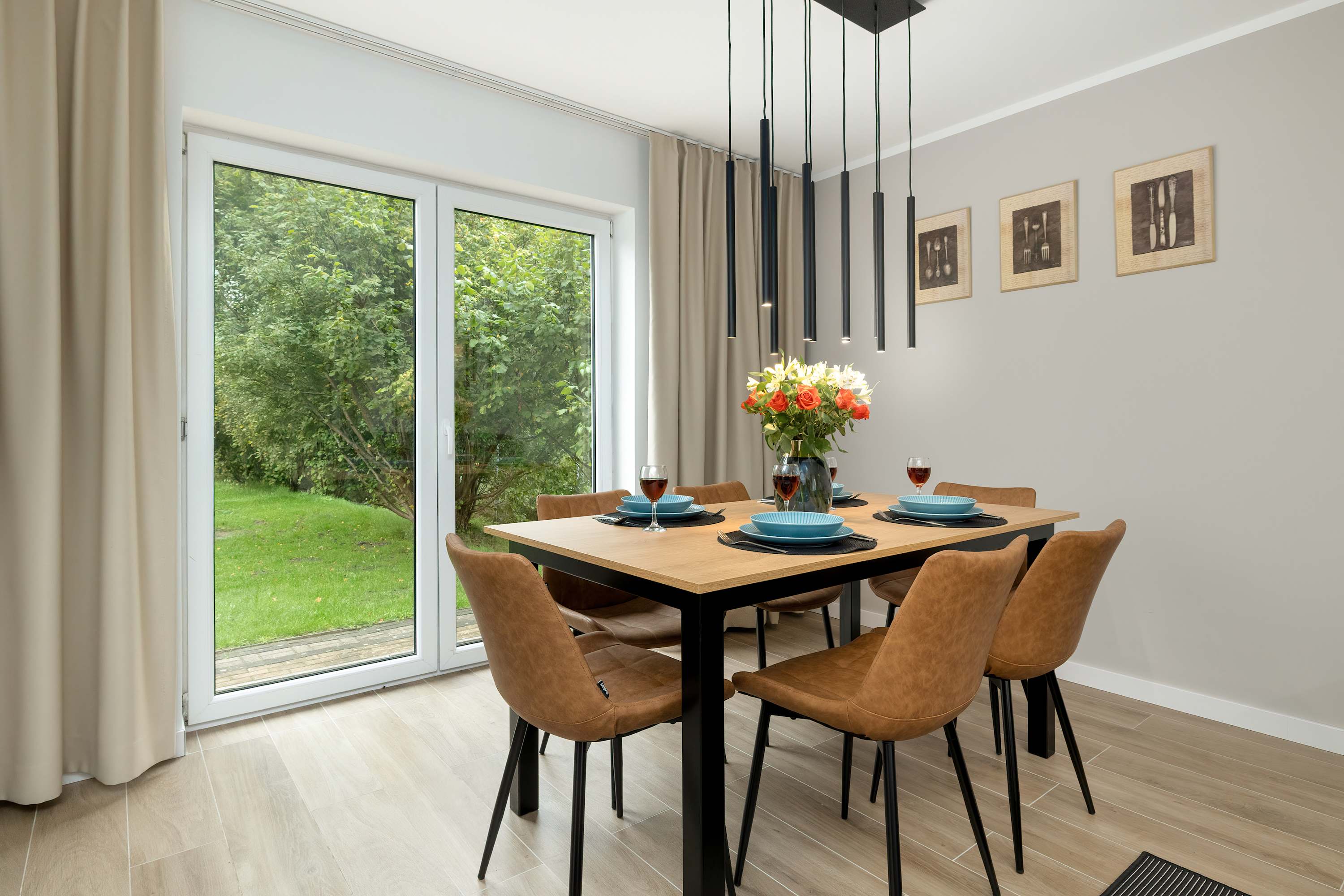 The dining table set by the glass doors leading to the garden makes it possible to enjoy meals in natural light.