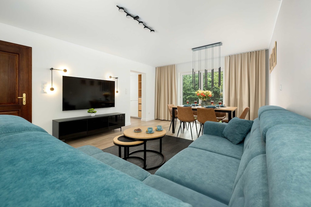 The modern living room with a large sofa and stylish lighting invites guests to enjoy time together in comfort.