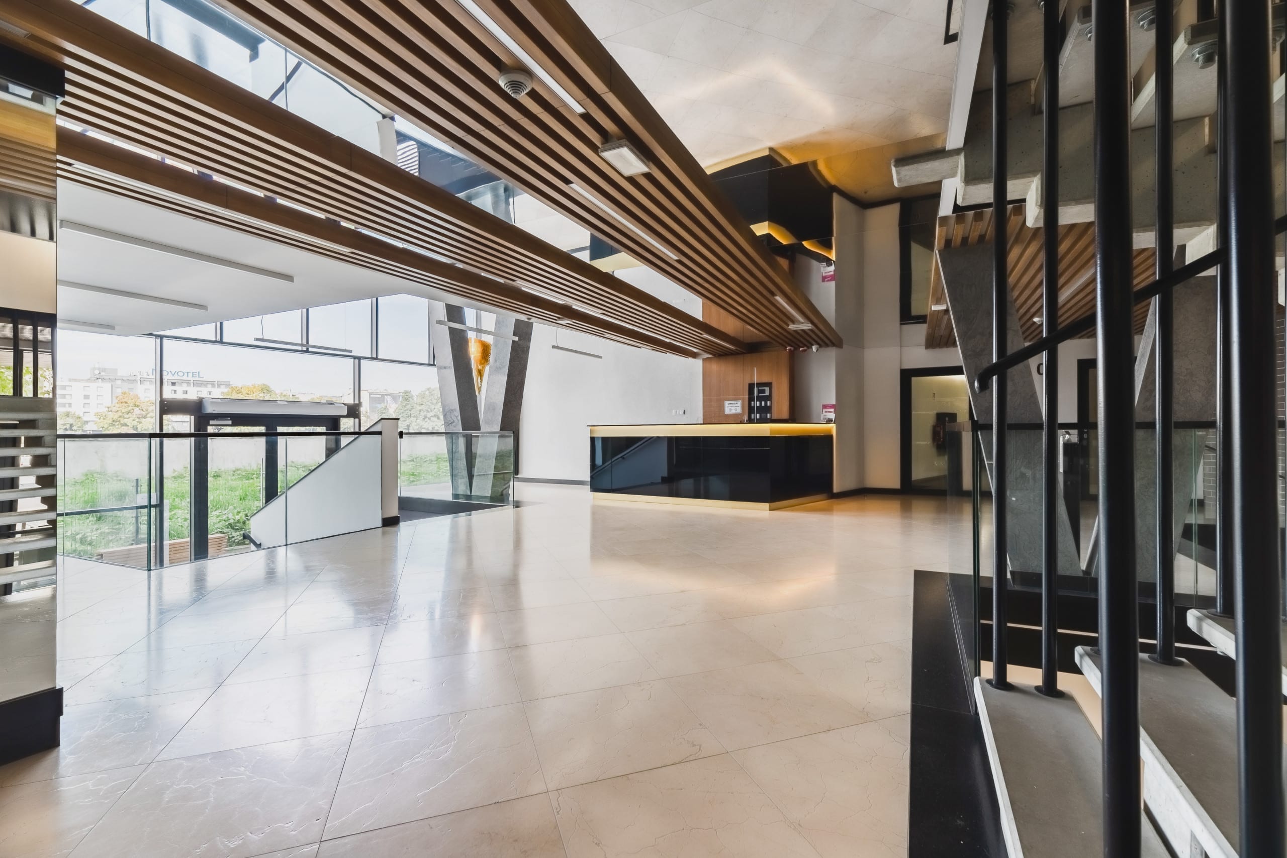 A luxurious lobby with large glass windows, seating areas, and contemporary decor.