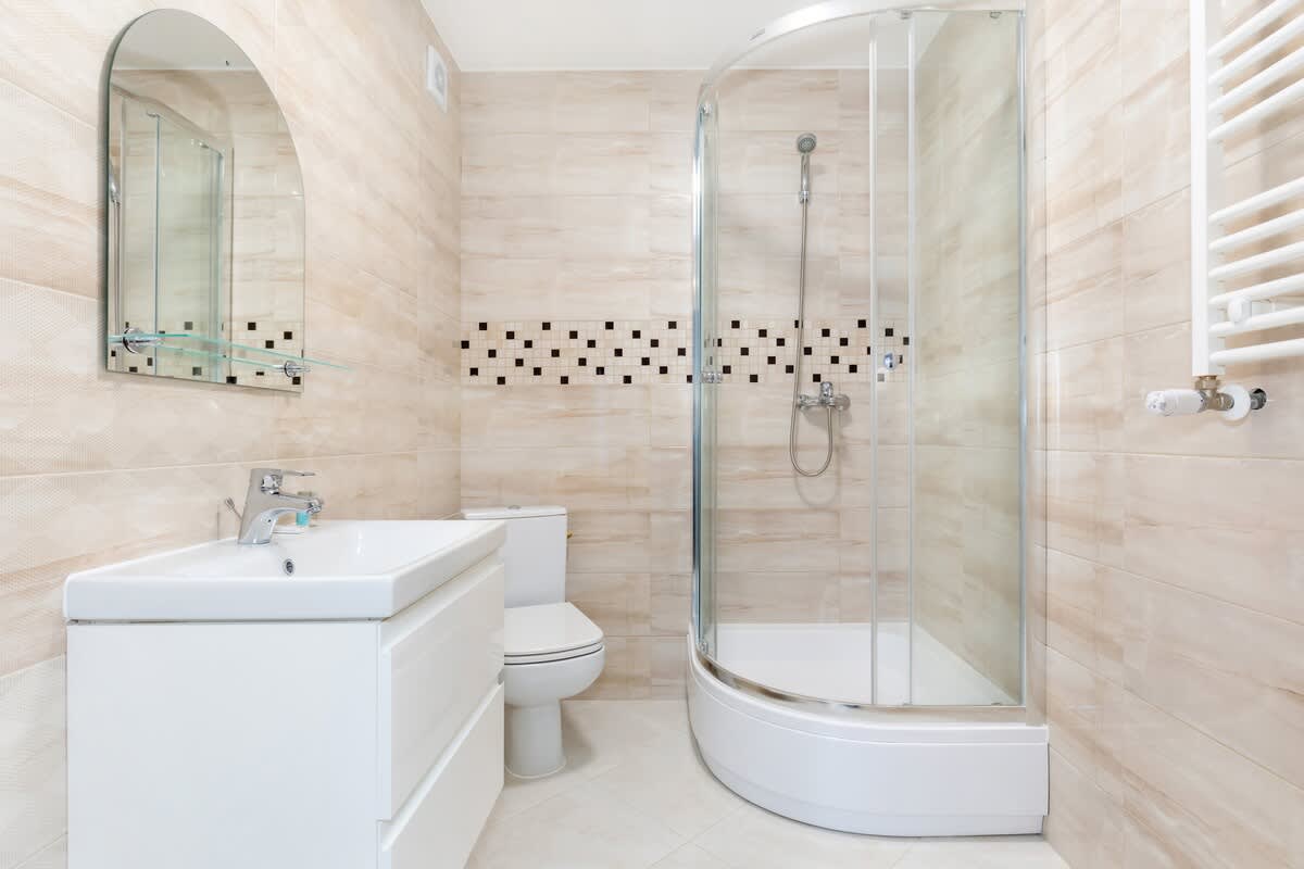 Bathroom with a shower, toilet, sink, mirror and hair dryer.