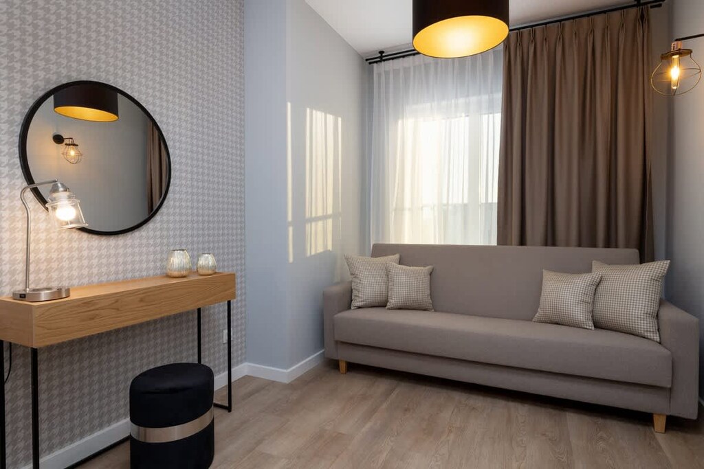  Another bedroom with a light-colored sofa, a small coffee table, and warm lighting, creating a relaxing atmosphere.