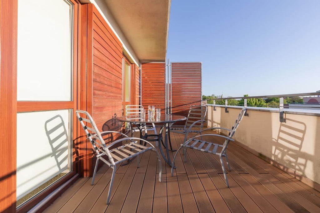 Spacious balcony with outdoor furniture. 