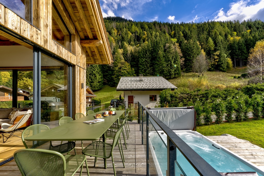 Balcony with dining furniture overlooking large hot tub