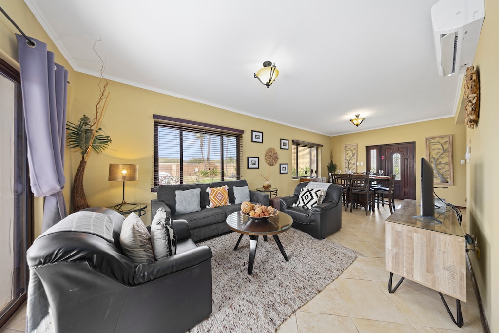- Relax in the generous living area of our townhouse in Noord Aruba. - The townhouse's living area combines stylish decor with cozy seating. - Large windows fill the living space with natural light. - The living area features a smart TV with Netflix.