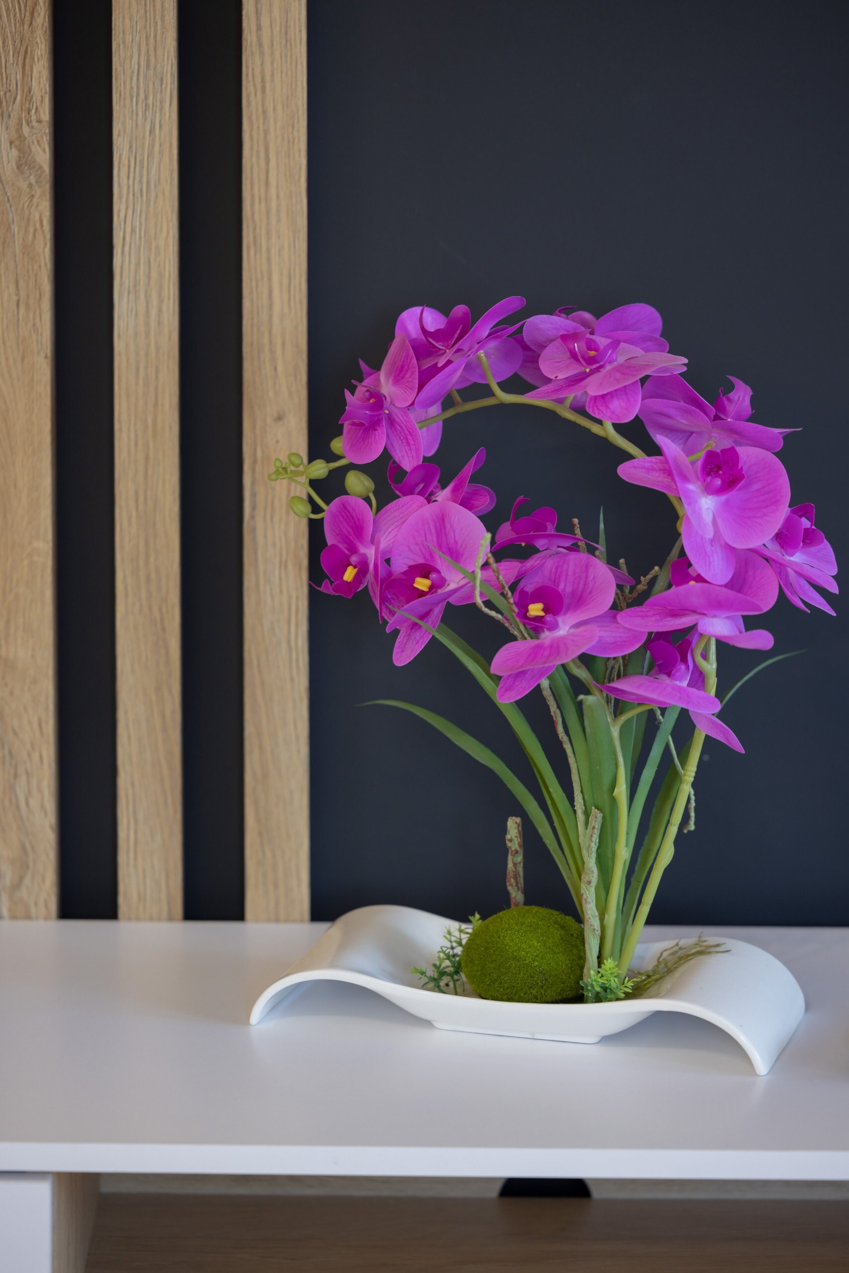 A small, colorful bouquet of purple flowers placed on a wooden surface, adding a touch of freshness and elegance to the interior.