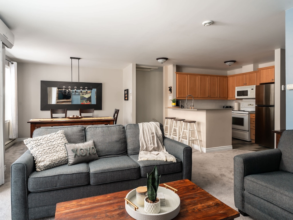 Salon baigné de lumière naturelle, offrant une ambiance chaleureuse et accueillante.