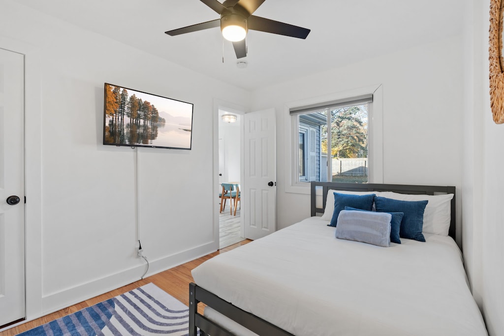 Unwind in your peaceful bedroom with crisp linens, a ceiling fan for comfort, and a wall-mounted TV for relaxing evenings.