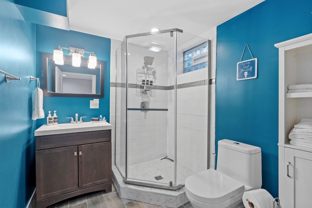 Refresh in your bright, modern bathroom featuring a spacious glass shower and vibrant blue accent walls that create an energizing start to your day.