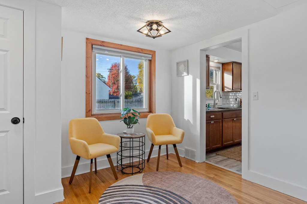 Settle into your cozy reading nook with warm yellow chairs and autumn views, perfectly positioned near your modern kitchen.