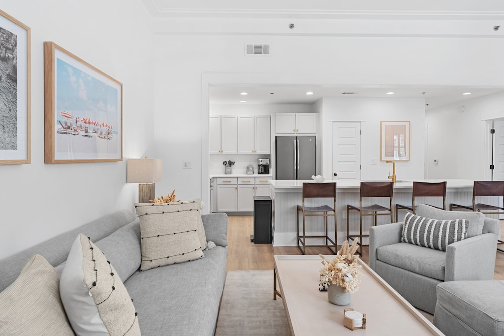 
A contemporary open-plan living room featuring a gray sofa and armchair with decorative pillows.