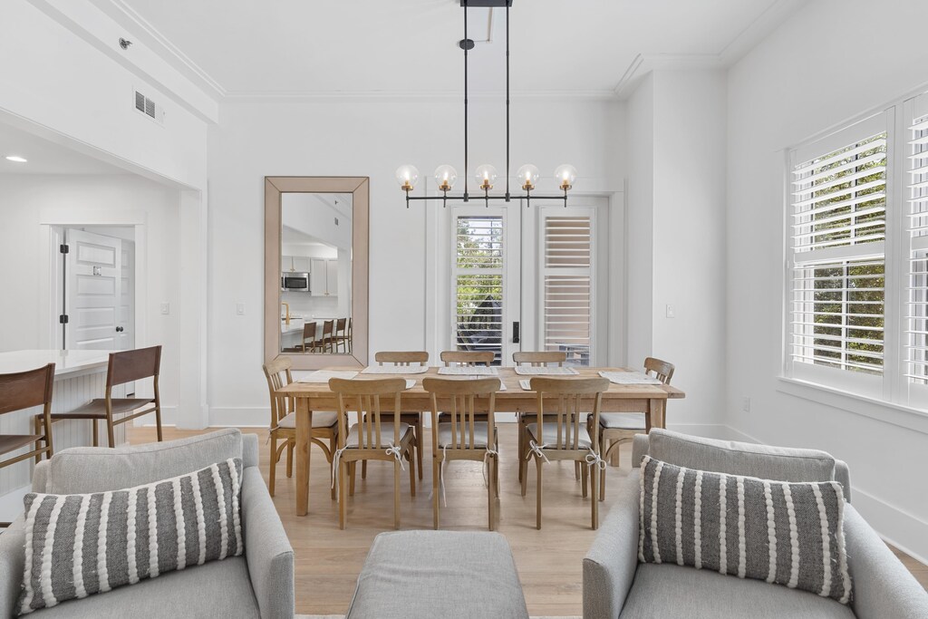 
A bright and modern dining room featuring a long wooden table with seating for 8.