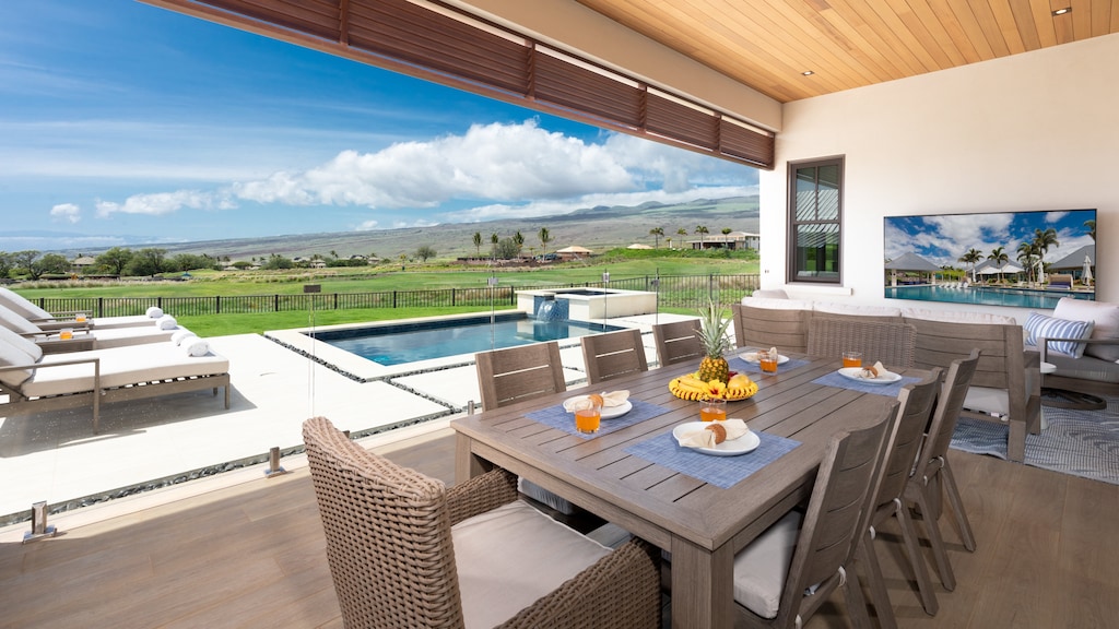 Outdoor living area with dining table & comfortable seating overlooking the pool, golf and ocean
