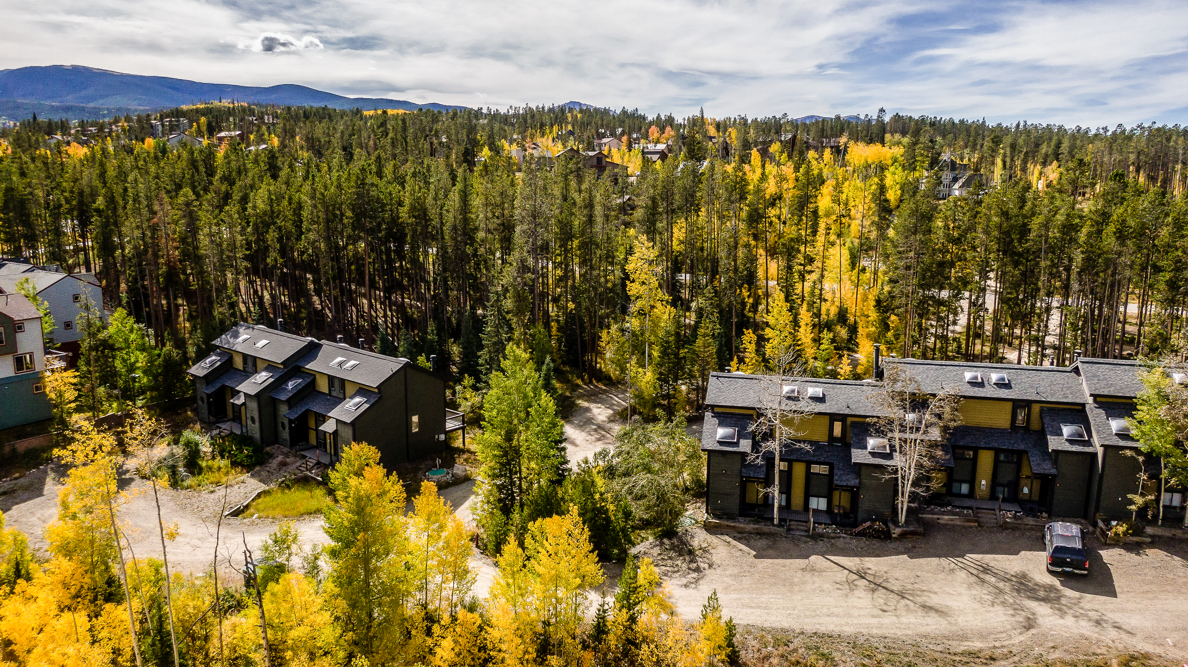 An aerial view of the home and the surrounding forest