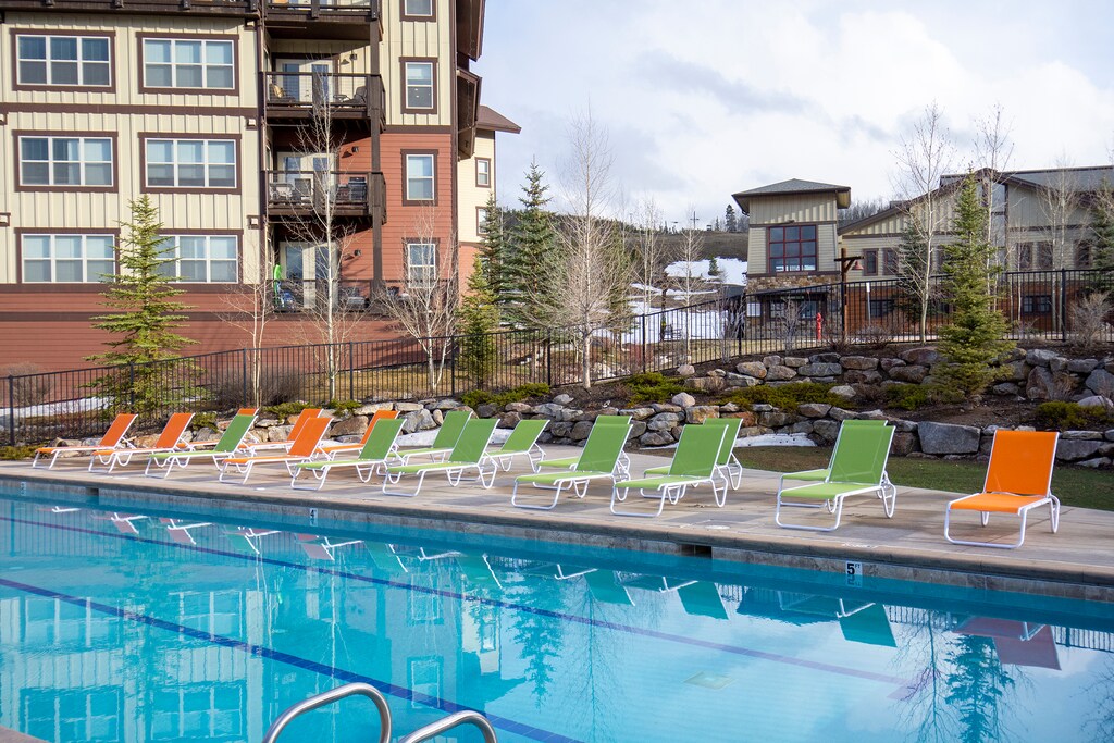 - Dive into relaxation at the sparkling outdoor pool with scenic views   - Lounge on colorful chairs after a refreshing swim in the mountain air   - Resort-style poolside seating makes every sunny day more enjoyable