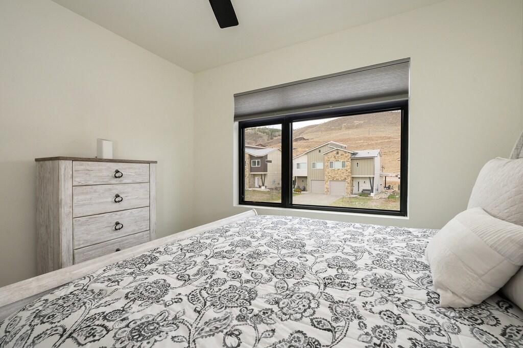 - Bright bedroom with large window overlooking mountain community views   - Sleek furniture and soft bedding create a peaceful space to recharge   - Natural light and simple style make this room restful and inviting