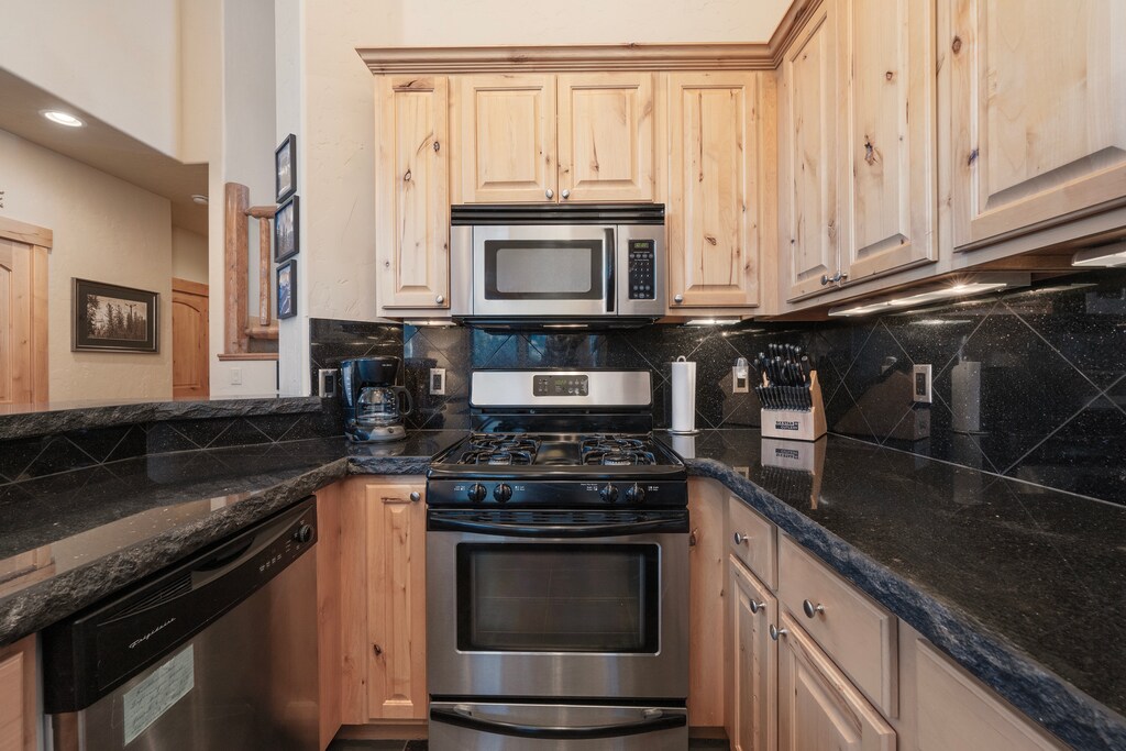 - Modern kitchen with stainless steel appliances and wood cabinets   - Fully equipped cooking space perfect for family ski meals   - Convenient layout with stove, microwave, and essentials