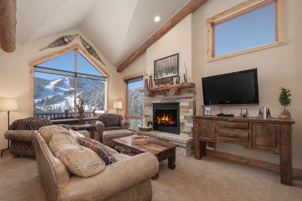 - Cozy living room with fireplace and mountain view   - Rustic alpine charm with vaulted ceilings and timber beams   - Relax after skiing with comfort and scenic backdrop