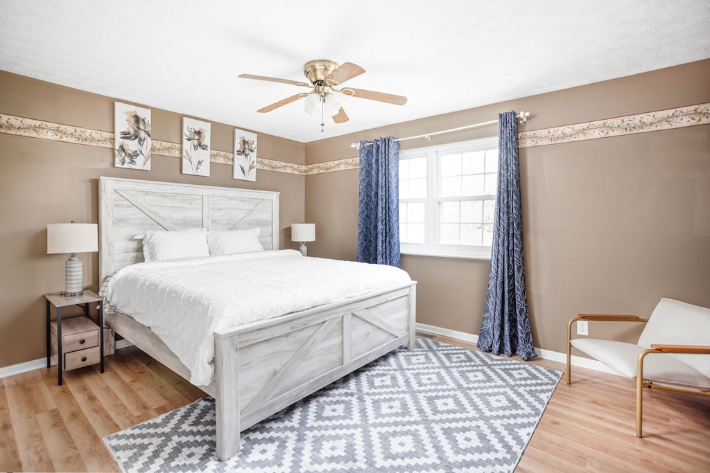 Unwind in this relaxing bedroom, adorned with tasteful decor. Complete with a bedside table, lamp, and additional seating, it's the perfect retreat.
