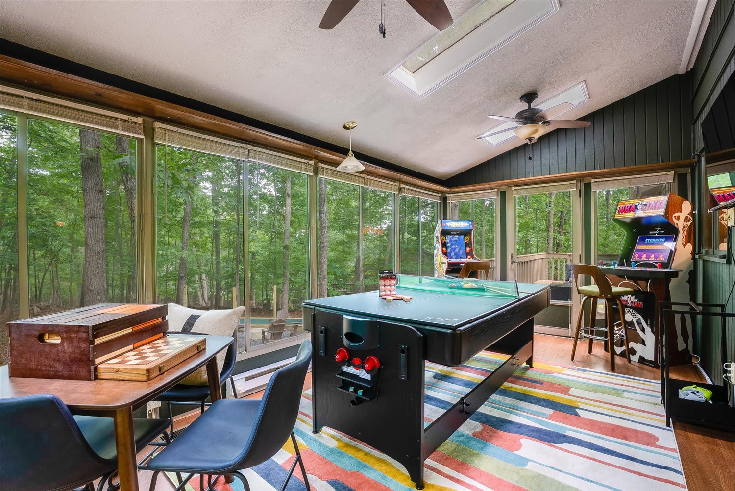 Nature meets entertainment in our game room, where expansive windows showcase breathtaking tree-lined vistas