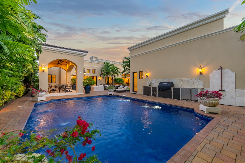 Private pool flanked by vibrant tropical flowers.