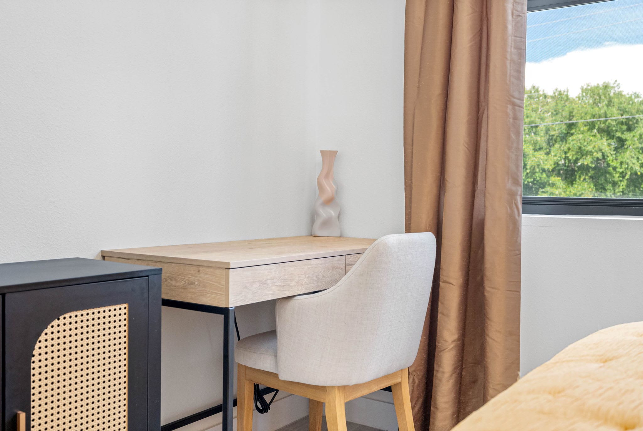 Enjoy a serene workspace with a desk and chair perfectly positioned beside the window, offering natural light and inspiration