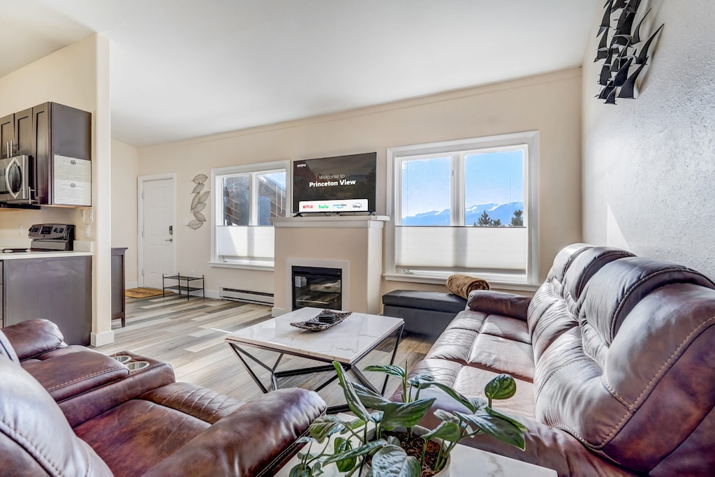 Welcome to Princeton View! In the inviting living room, a cozy sofa awaits. Enjoy the warmth and ambiance while catching up on your favorite shows or movies on the smart TV. The stylish decor adds a touch of charm to this perfect spot for unwinding.