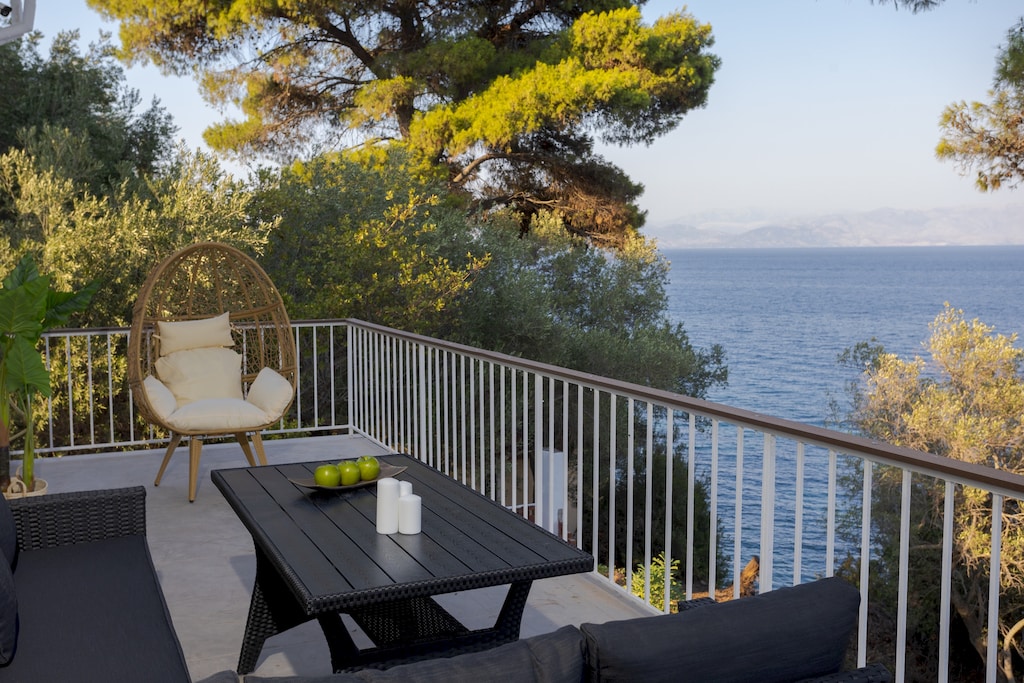 Sea-view balcony nestled in trees with cozy outdoor seating

