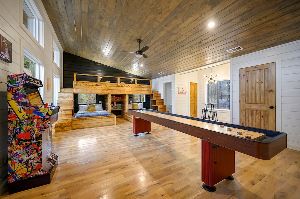 Upstairs bunk/game room features a shuffleboard table, arcade, and sleeping for 4-6 guests