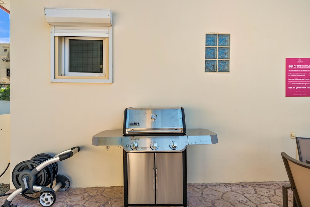 - Outdoor grilling station featuring a sleek stainless steel barbecue, perfect for summer cookouts - Conveniently located on a stone patio with easy access to outdoor dining areas - A great spot for enjoying meals al fresco with family and friends