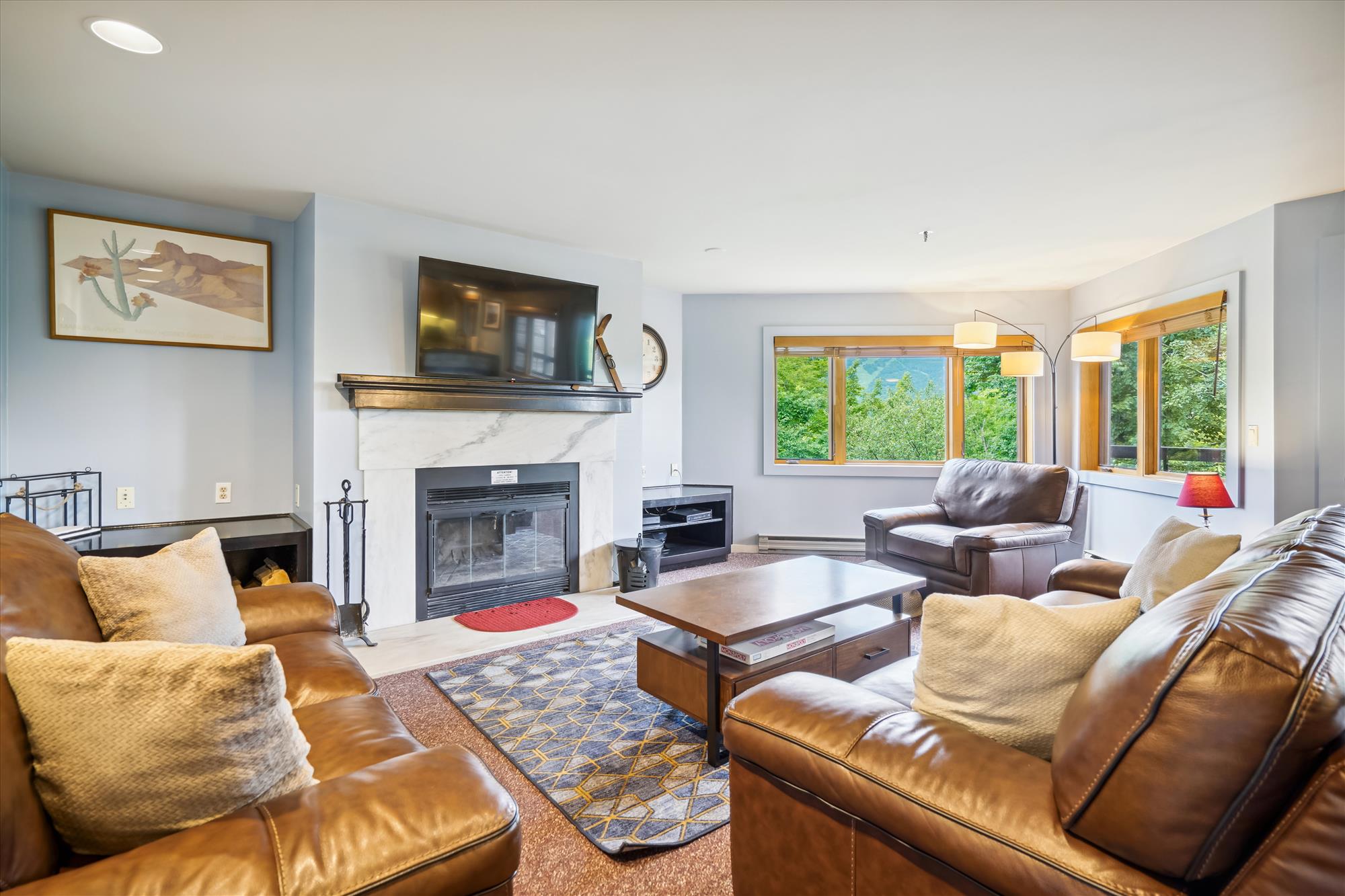 Bright and spacious living room with a fireplace. Lots of natural lighting and great views.